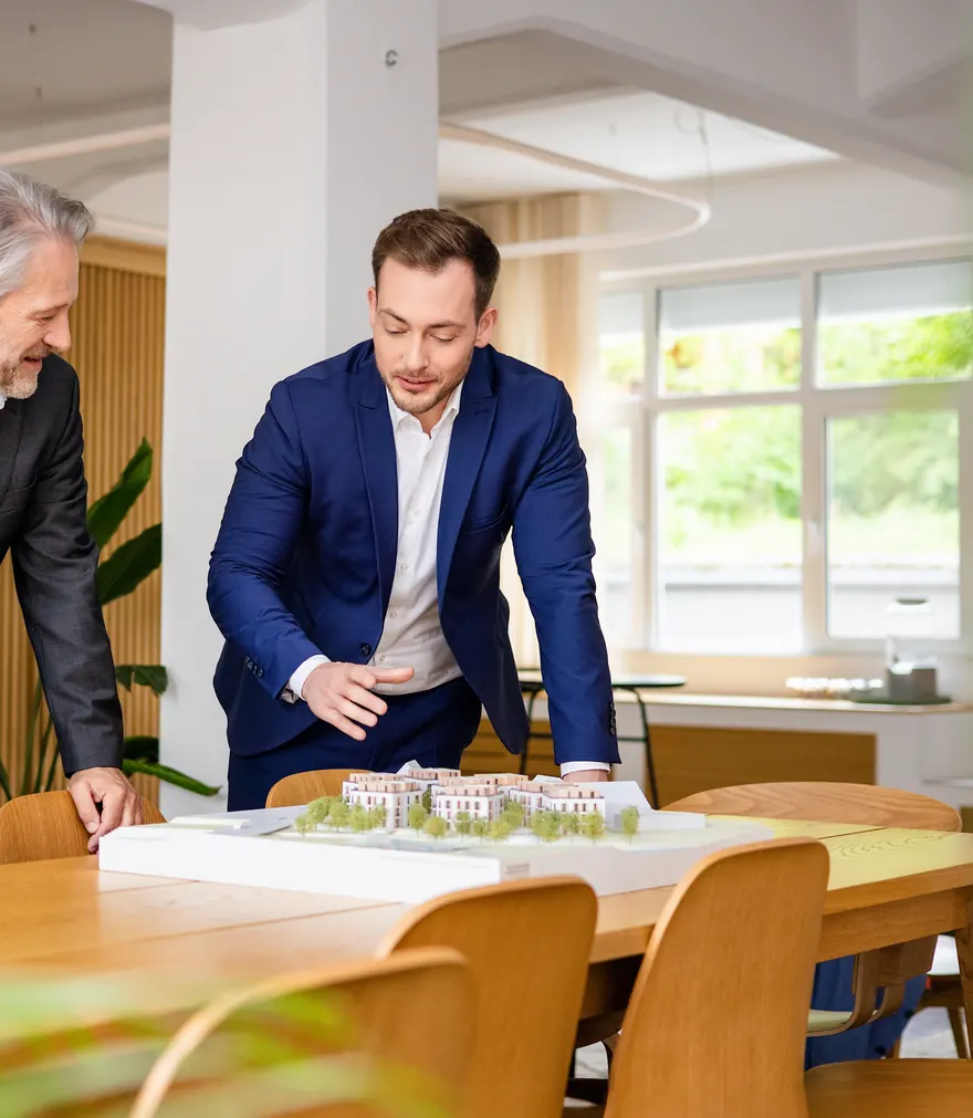 Erik Porthun bespricht mit einem Eigentümer ein Neubauprojekt im PORTIMMO-Büro